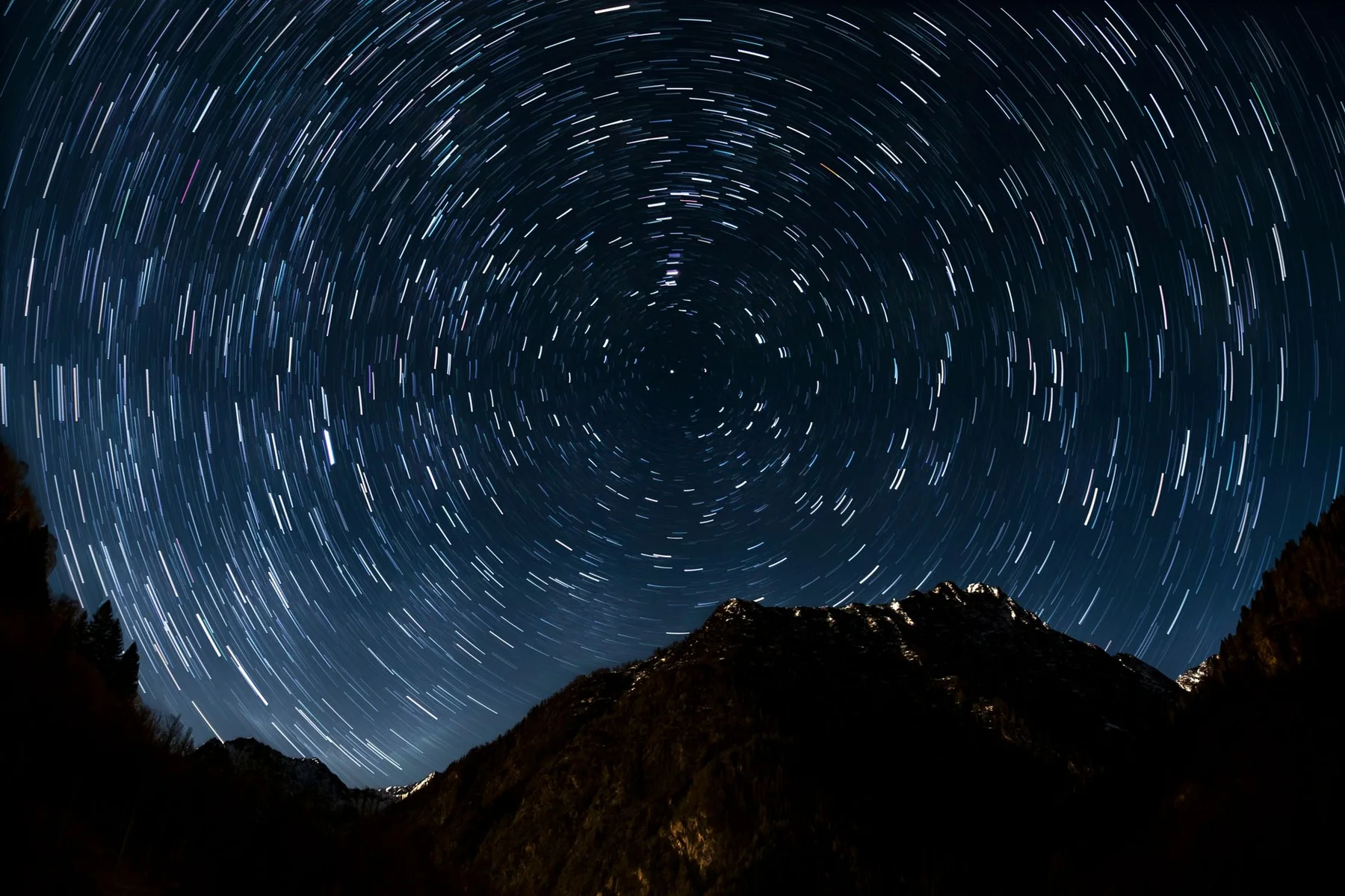 Cielo nocturno con estelas luminosas de estrellas